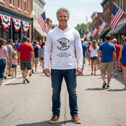 Man wearing Lightweight Hoodie from Stormy's Pub & Grub, standing in a crowd during a festive outdoor event.