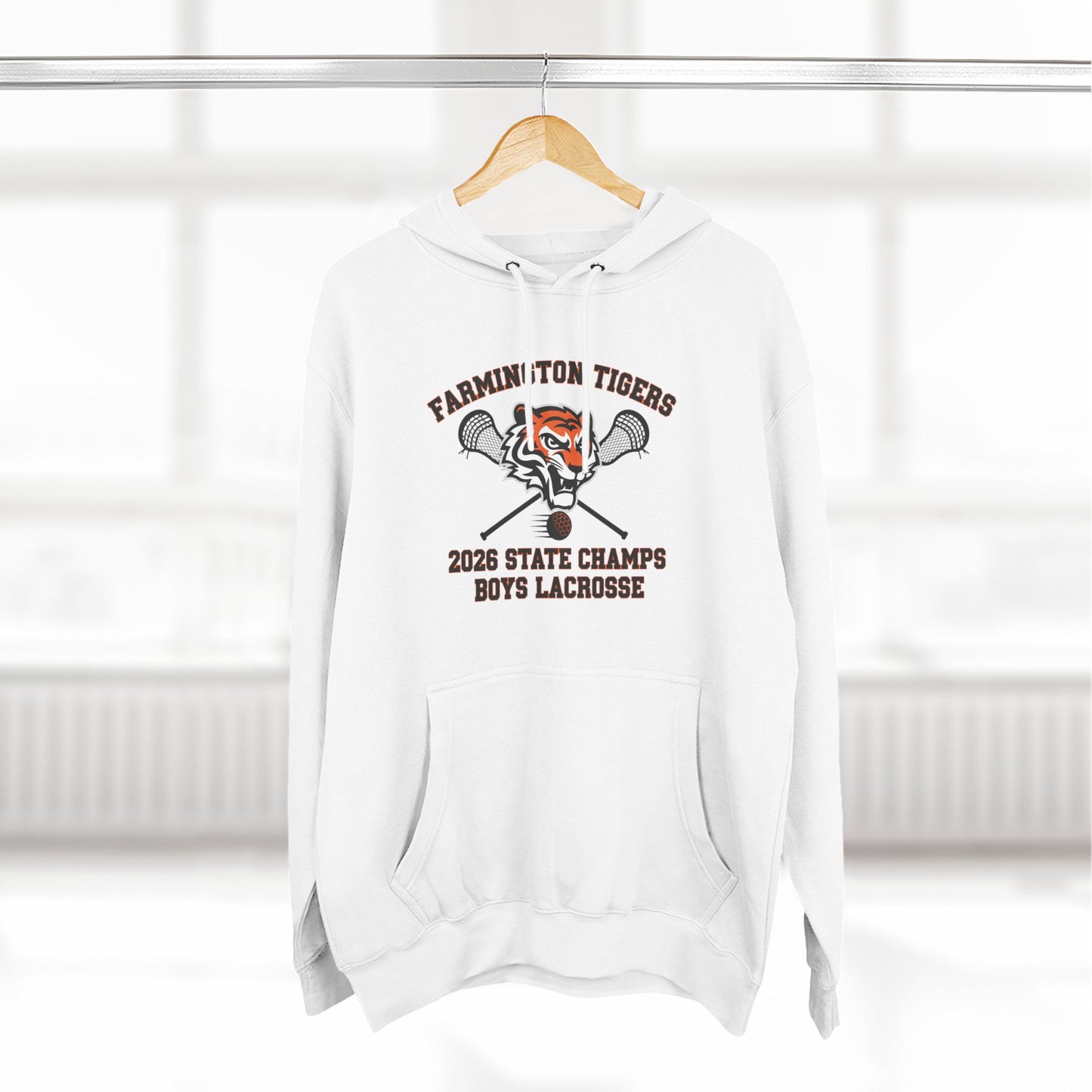 Farmington Tigers 2026 State Champs Boys Lacrosse Fleece Hoodie displayed on a hanger in a bright room.